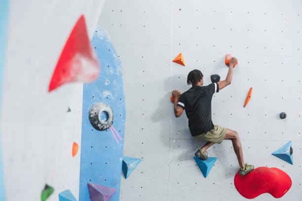 Persona escalando muro vertical
