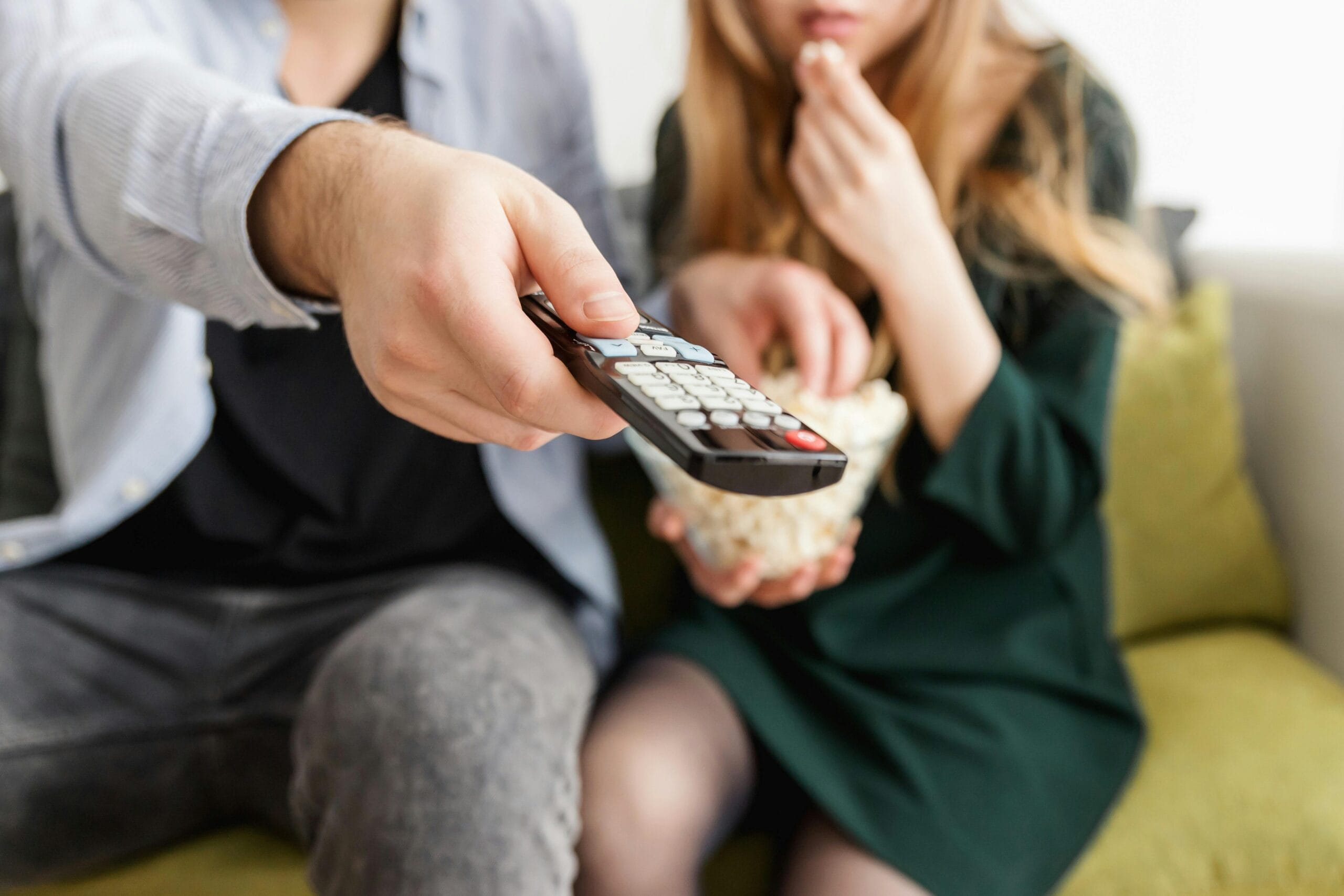 Cine en casa Personas viendo televisión en una noche de películas en casa y comiendo palomitas y usando control remoto